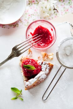 Delicious freshly baked cheesecake with raspberry coulis on top and mint