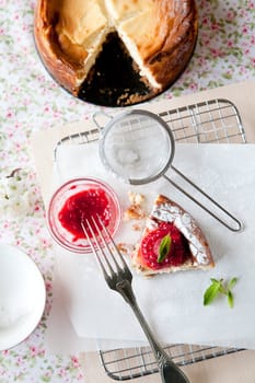 Delicious freshly baked cheesecake with raspberry coulis on top