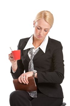 Attractive young businesswoman sitting and waiting with a cup of coffee