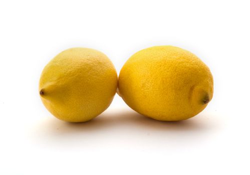 Two whole fresh lemon on a white background