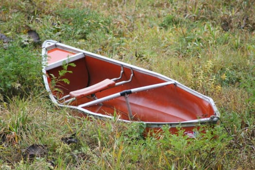 kleines rotes Ruderboot liegt auf dem Trocknen	
little red rowing boat is on dry land