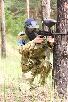 paintball player aiming in the forest