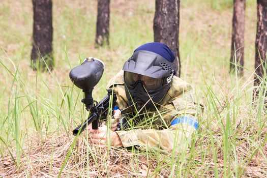 Paintball player lying in the grass