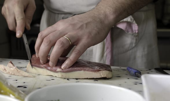 a cook cutting meat