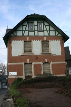 Ein altes renovierungsbedürftiges Fachwerkhaus, mit blauem Himmel im Hintergrund	
an old half-timbered house in need of renovation, with blue sky background