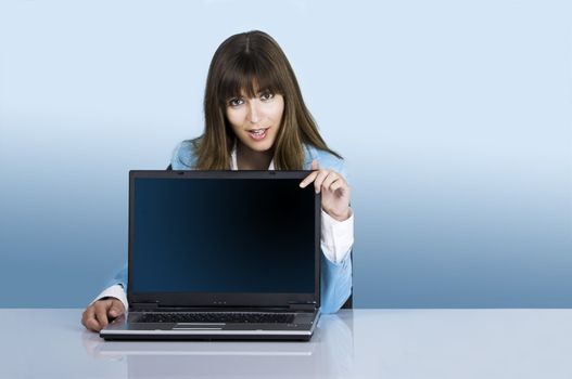 Satisfied businesswoman showing a presentation with a laptop on a blue background (This file include a path on the laptop screen)
