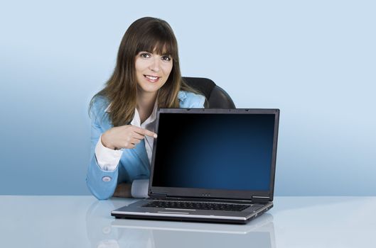 
Satisfied businesswoman showing a presentation with a laptop on a blue background (This file include a path on the laptop screen)
