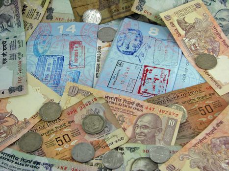 India currency on top of passports with visas.