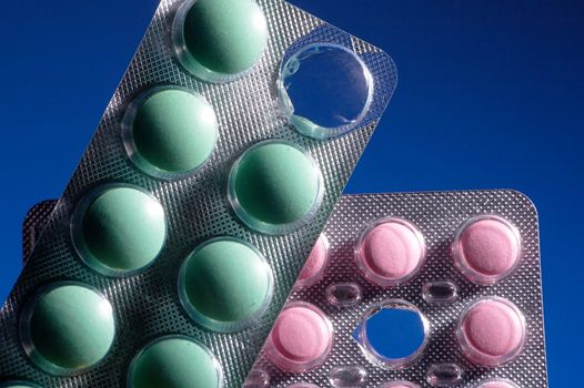 Pink and green tablets on a dark blue background