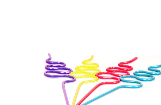 Party Straws with Copy Space is a capture of purple, yellow, red and blue curvy party straws isolated over a white background.
