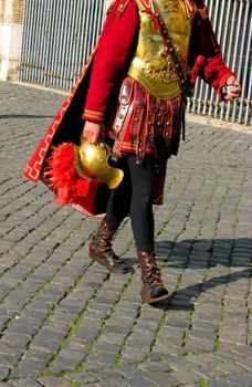 A Roman Gladiator walks past the Coliseum in Rome with his trusty cell phone - probably calling Caesar.