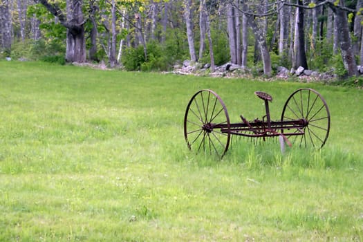 antique hay rake in a field
