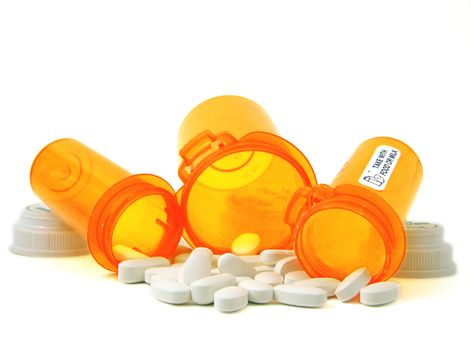 A group of medications with three orange prescription bottles.