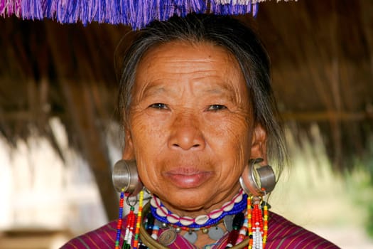 Woman on the Black Karen tribe in Thailand. The women can either choose to have rings around their necks or huge earrings