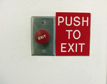 A sign on an exit door wall provides instructions - Push To Exit.