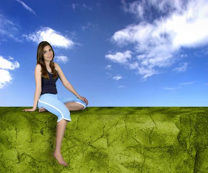 Beautiful athletic woman with different poses seated on a green wall
