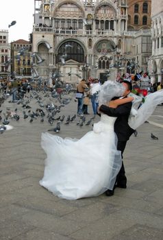 A young couple celebrates their wedding day in historic and romantic Venice - St. Mark's Square.