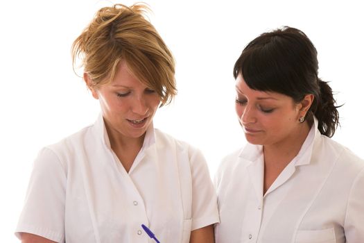 Two nurses on white background discussing their patients and checking notes