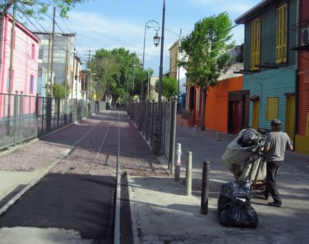 A worker removes trash along the train tracks in the colorful La Boca district of Buenos Aires, Argentina.