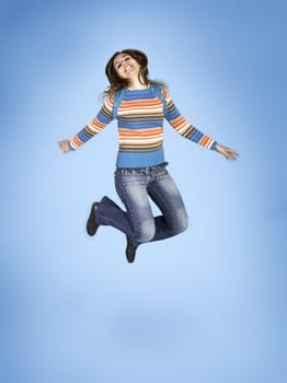 Beautiful woman jumping over a blue