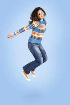 Beautiful woman jumping over a blue