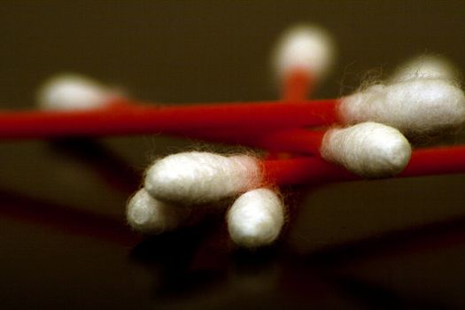 Cotton Swabs with red shafts are captured using depth of field to show the detail in the white cotten swabs.
