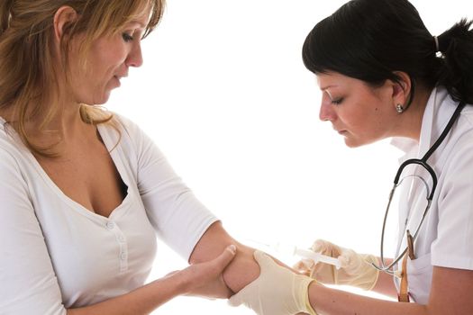 Nurse looking where the right vein is to inject her needle in while her patient looks a bit scared