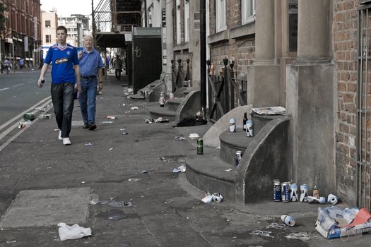 Rangers fan walking in a street littered with rubbish before the UEFA cup 2008