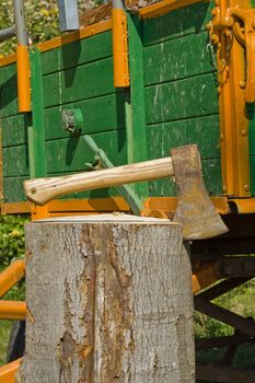 A trailer load with wood, before it an axe in log