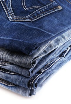 Five pairs of jeans, isolated on a white background.