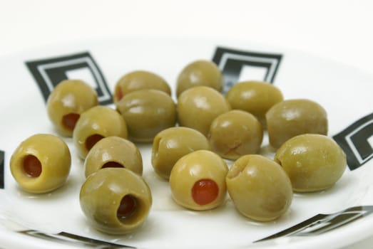 A bunch of green olives on a plate.
