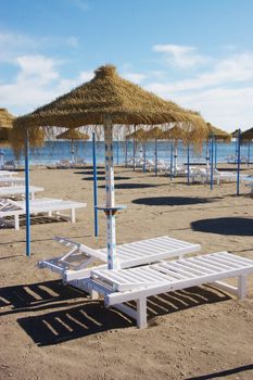 sunbeds and parasols set out on a sandy beach