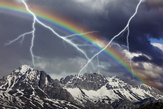 Big thundershower with ray and rainbow in the mountains