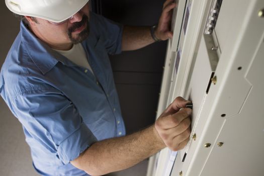 An engineer adjusting Voltage levels on the power panel.