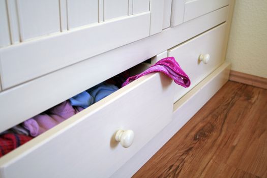 white furniture with open drawer and underpants