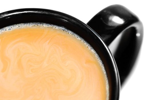 Close-up of a cup of latte, coffee with cream or milk swirls in a black mug isolated on white background.