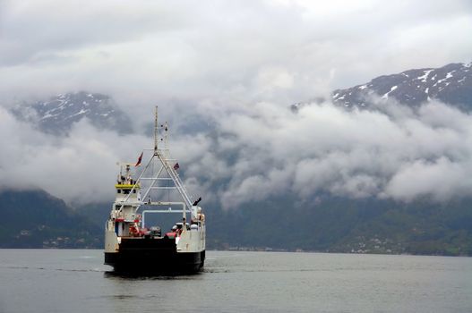 A ferry with cars crossing a Norwegian fjord