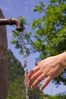 woman hand under fresh water