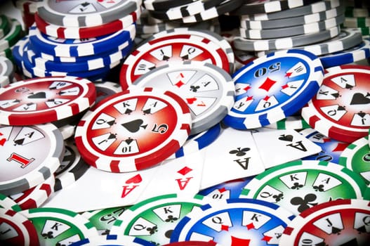 Piled colored chips with four aces isolated on white background