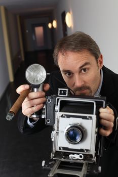 Photo of a retro 1940's style photographer taking a photo with an old 4x6 camera.