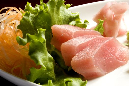 Sashimi on a platter with carrot and lettuce