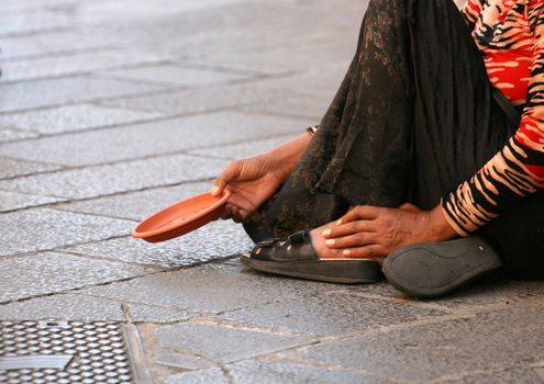 hands stretching out begging for some loose chain sitting in the street