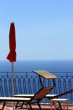 Red umbrella and sunbeds overlooking the Mediterrean Sea in Sicily