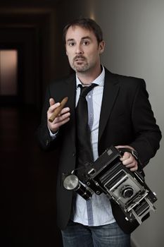 Photo of a retro 1940's style photographer with an old 4x6 camera.  Desaturated for more retro feel.