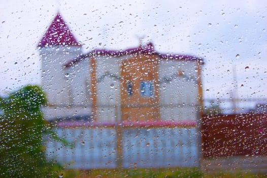 house and the rain through wet glass