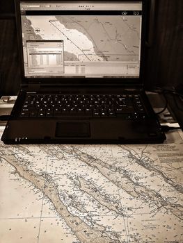 Sailing navigation. Traditional map and modern computer based gps system.            