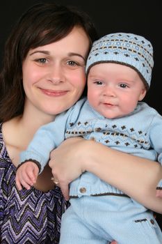 Beautiful brunette mother with her baby boy dressed in blue
