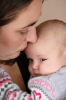 Beautiful brunette mother holding her two month old baby girl 