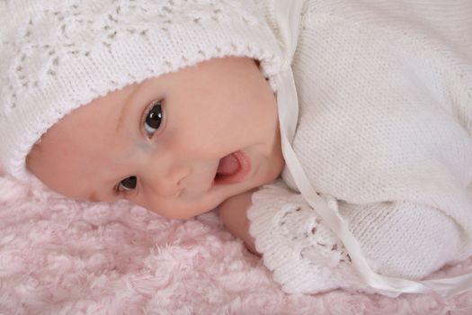 Beautiful two month old baby girl wearing a knitted outfit 