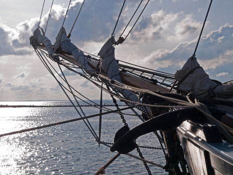 Traditional vintage wood sailboat sails out into the sea